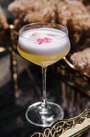 Glass with yellow lemon cocktail with foam photo