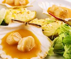 Seared scallops shell with butter on plate photo