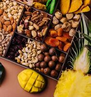 Assorted nuts and dried tropical fruits in a wooden box photo