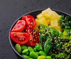 bowl with seaweed, beans, avocado and pineapple photo