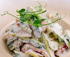 Salad with fresh vegetables and cream sause on plate photo