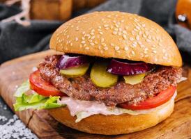 Close-up of home made burger on wooden tray photo