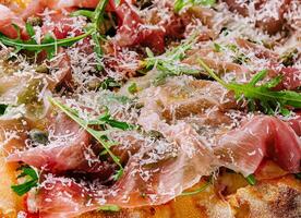 square pizza with prosciutto and arugula photo