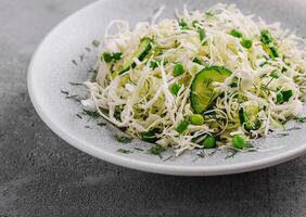 Spring vegan salad with cabbage, cucumber, green onion and peas photo