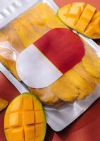 pack of dried mango slices and raw mango photo