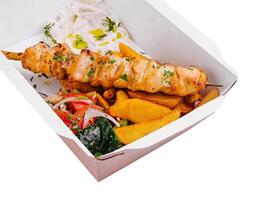 Chicken skewers with potatoes and tomato and onion salad photo