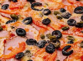 Pizza with ham, parmesan cheese and olives photo