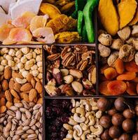 Assorted nuts and dried tropical fruits in a wooden box photo
