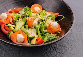 Salmon salad with mozzarella, tomato, cucumber on bowl photo