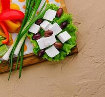feta cheese with olives on a wooden tray photo