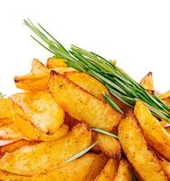 Baked potato wedges with rosemary closeup photo