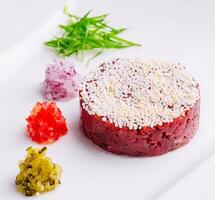 Chopped beef, steak tartare served with yolk and pickles photo
