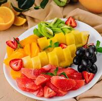 assorted sliced tropical fruits on plate photo