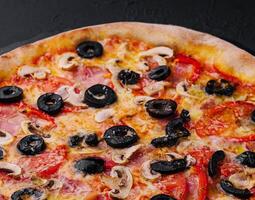 Pizza con tomate, Olivos, champiñones, jamón y queso foto