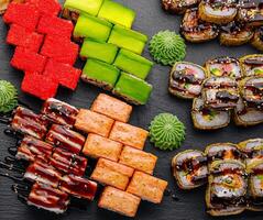 Large sushi set, shot from the top on a black background photo