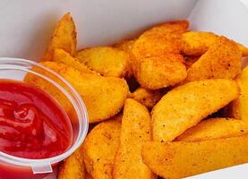 Fried potato wedges in takeaway box photo