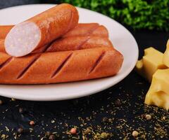 boiled sausages with cheese on plate photo