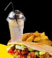 Tasty chicken doner kebab with fried potato on a wooden table photo
