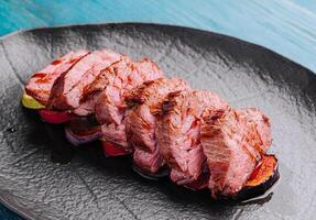 fried pork on eggplant on black plate photo