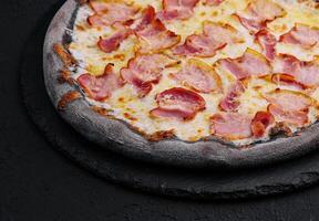 black dough pizza with cheese and ham photo