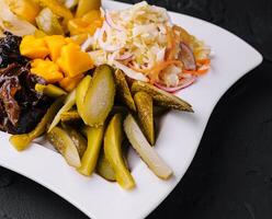 Marinated salty vegetables in the plate photo