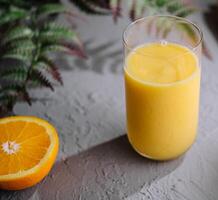 Yellow smoothie of mango, banana and orange photo