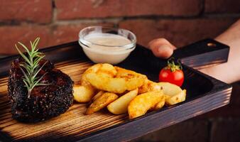 Tasty beef steak with baked potatoes photo