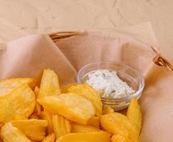 Potato wedges in basket and sauce photo