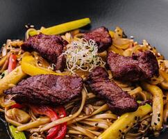 Chinese noodles with roasted duck and fried vegetables photo