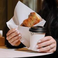 Girl Eating Croissant with Pistachio Powder and Drinking Coffee on Terrace photo