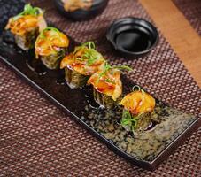 Salmon sushi temaki on black plate photo