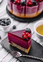 berry mousse cake with red icing and tea photo