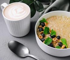 Oatmeal porridge with hazelnuts and blueberries in bowl photo