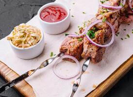 jugoso kebabs desde Cerdo en brochetas puesto fuera en un decorativo tablero foto