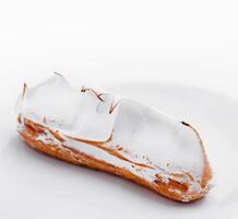 eclair with meringue on white plate photo