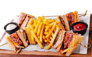 Mini sandwiches with ham and fries with sauces photo