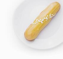 Delicious eclair with custard on plate top view photo