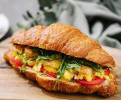 Croissant stuffed scrambled eggs with shrimps photo
