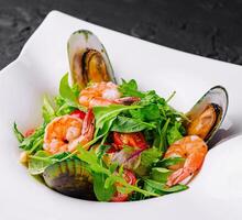 Seafood salad with shrimps and mussels on plate photo