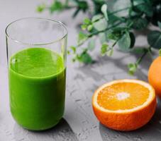 Freshly made spinach smoothie and orange photo