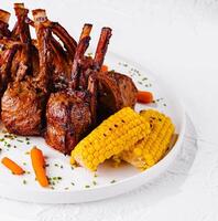 rack of lamb with corn and carrots photo