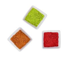 red, yellow and green indian spices in a ceramic bowl photo