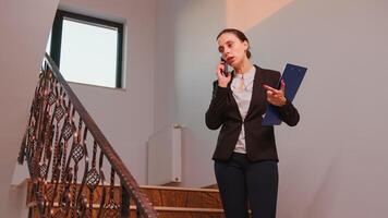 nervioso mujer de negocios Hablando en teléfono inteligente con empresa gerente en pie en escalera en Finanzas edificio trabajando con el tiempo. grupo de profesional gente de negocios trabajando en moderno finacial lugar de trabajo. foto