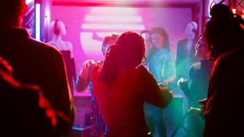 personas ir de fiesta interrumpido por policía oficiales, joven adultos viendo policía sirenas o luces y parada el música. hombres y mujer siendo temeroso de ley aplicación a Club nocturno. Mano disparo. foto