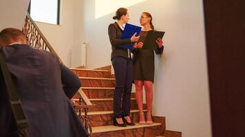 Team of business people and manager executive standing and walking on a staircase, talking holding clipboards. Group of professional successful businesspeople working in modern financial building. photo