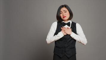 frente escritorio personal sensación aburrido y soñoliento en cámara, relación comercial con agotamiento y Confusión terminado gris antecedentes. recepcionista con uniforme y Corbata siendo agotado y incierto. cámara una. foto