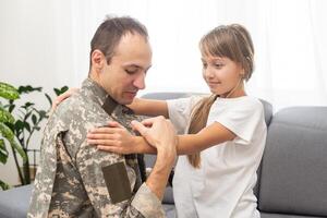 Military dad hugging his daughter photo