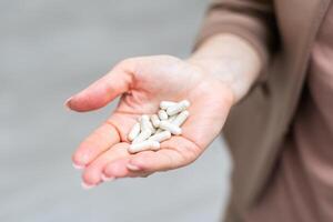 Hand holding pills. Isolated on white background photo