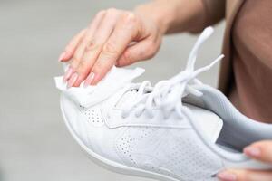 Cleaning white sneaker with cloth photo