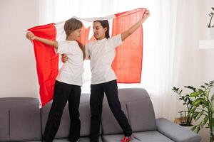 Happy Canada Day Celebration. Two girls with big Canada flag in their hands. Young Canadian caucasian kids 1st of July. photo